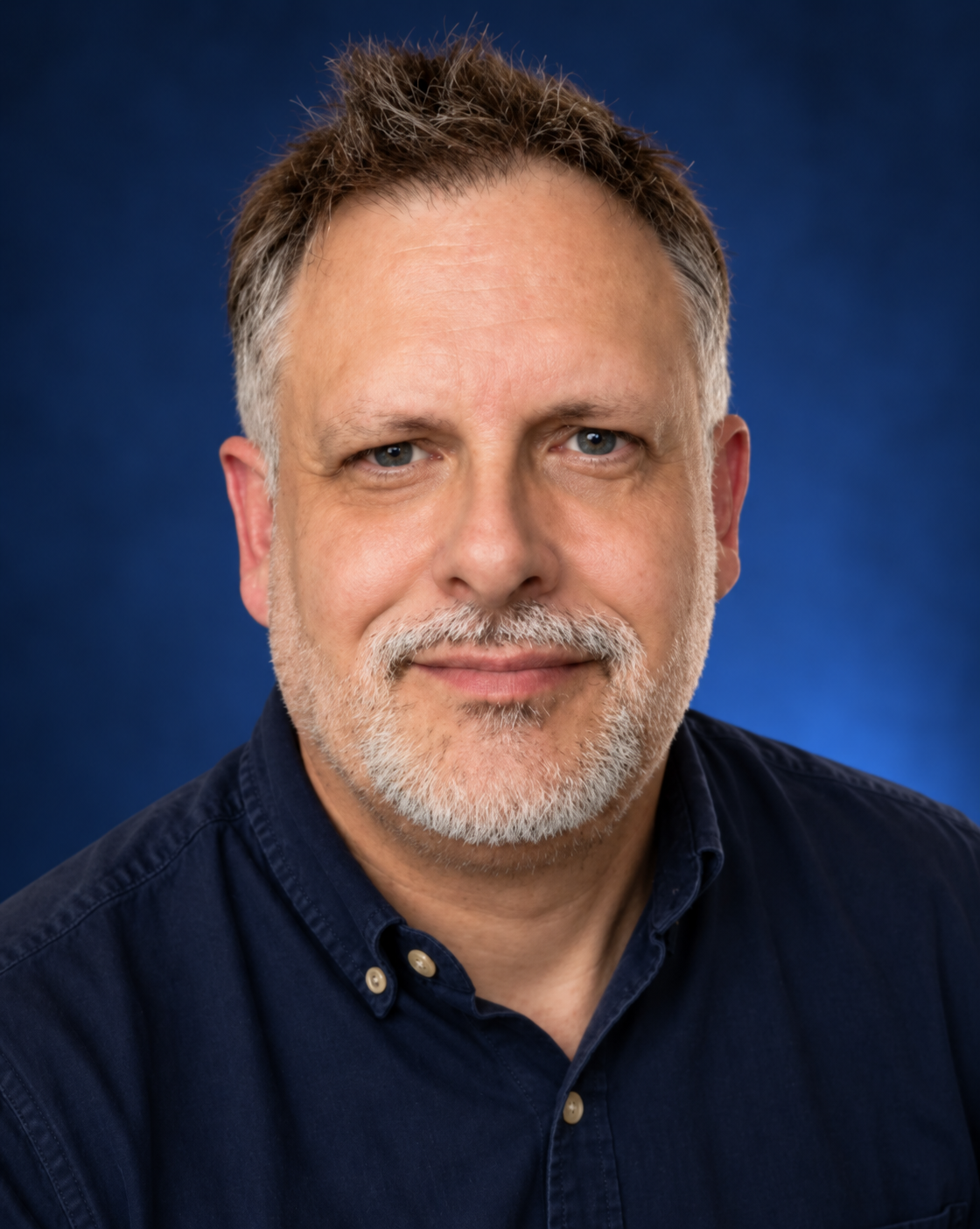 Portrait of Quintin Smith against a blue backdrop